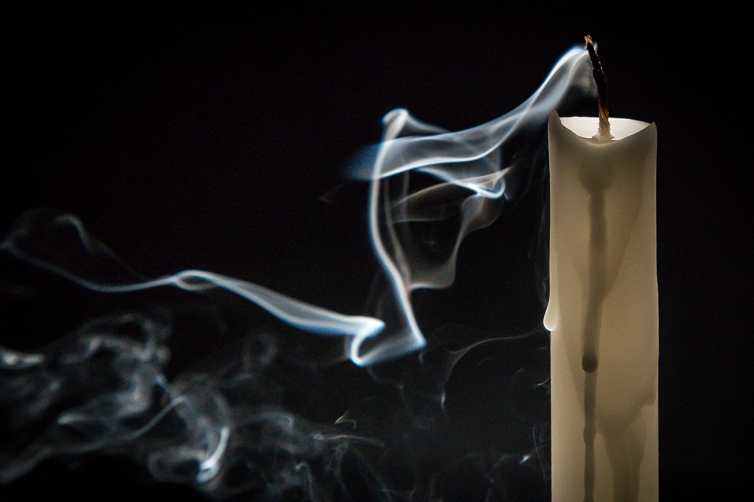 Погасшая свеча на черном фоне